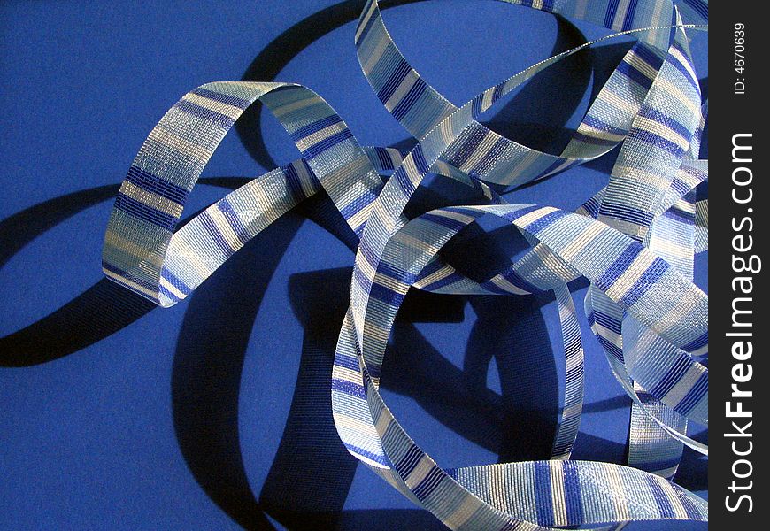 Blue striped ribbon against blue background. Blue striped ribbon against blue background