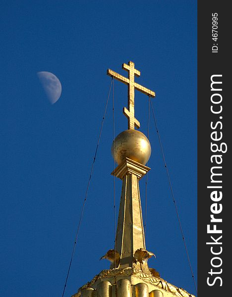 Golden orthodox cross on blue sky with moon. Golden orthodox cross on blue sky with moon.