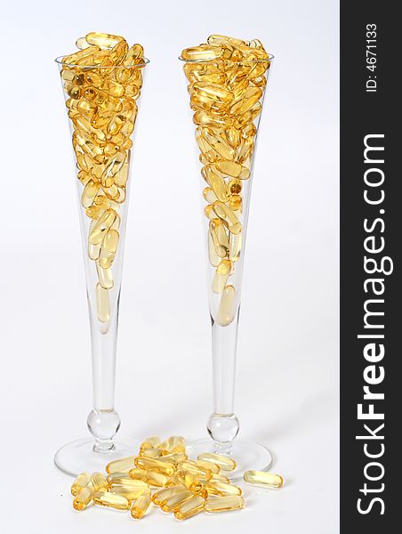 Two glasses with gold shiny boluses. Two glasses with gold shiny boluses