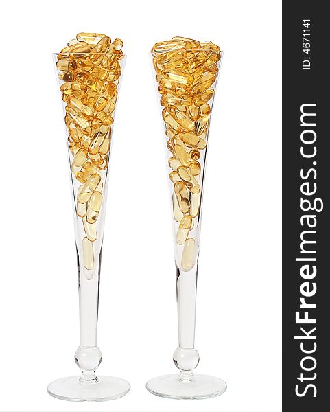 Two glasses with gold shiny boluses. Two glasses with gold shiny boluses