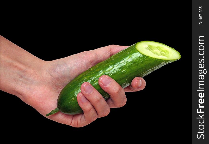 Hand holding a cucumber on black background