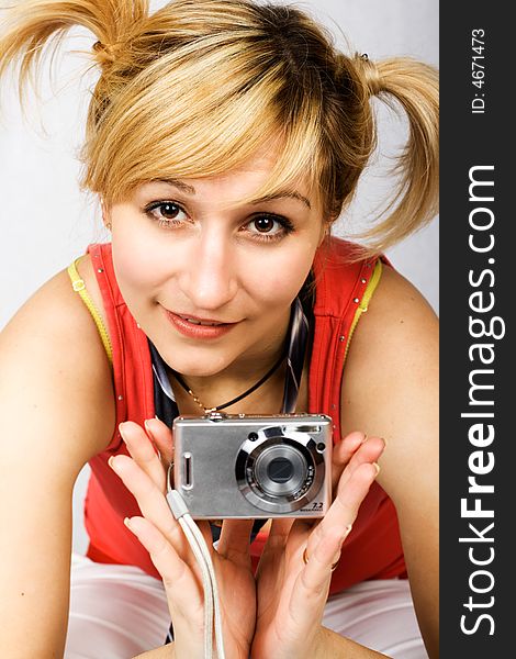 Young girl clothed in T-shirt holding digital camera