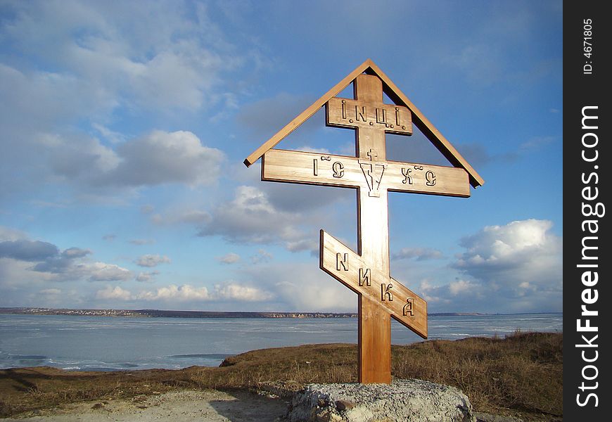 Winter. Wooden christian cross on the coast of the river. Winter. Wooden christian cross on the coast of the river.