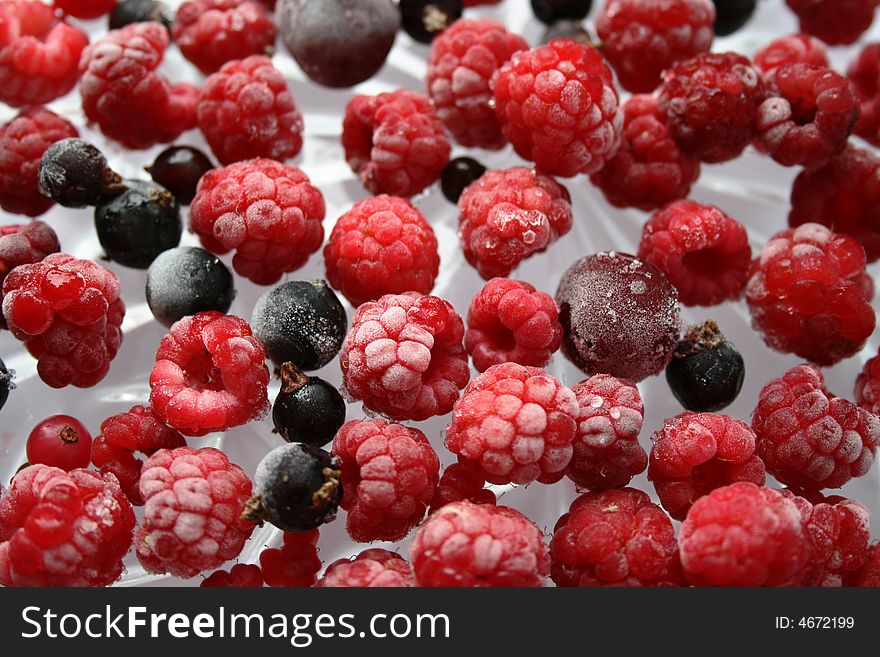 Frozen raspberries and blackberries on glass. Frozen raspberries and blackberries on glass