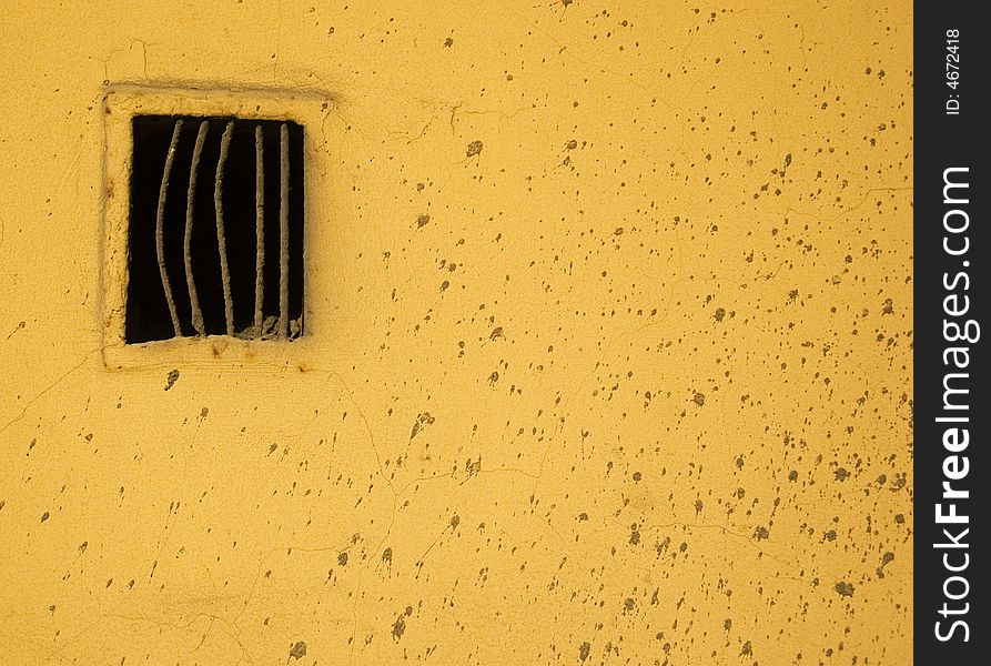 Yellow wall with ventilation and dirt spots