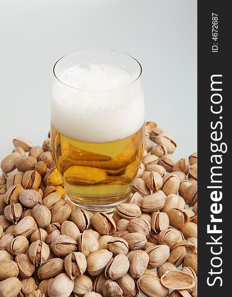 Beer in glass with pistachioes. Beer in glass with pistachioes