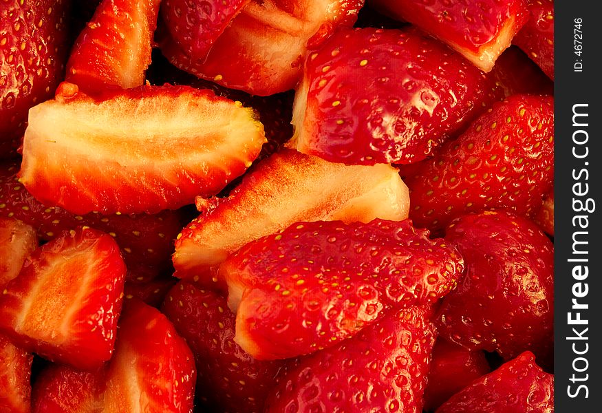 A background of red cut strawberries. A background of red cut strawberries