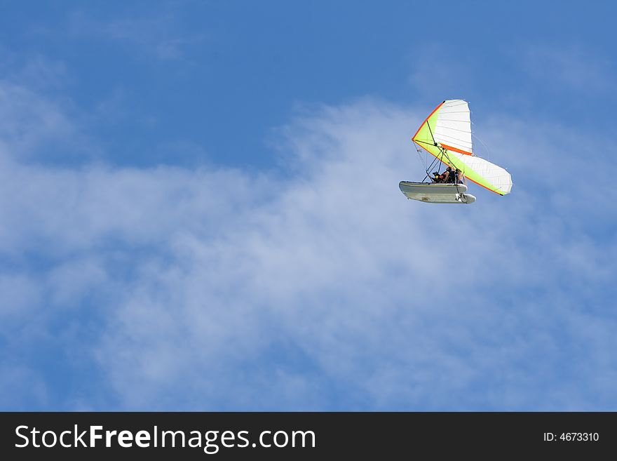 Hang-glider in a blue sky with two men onboard