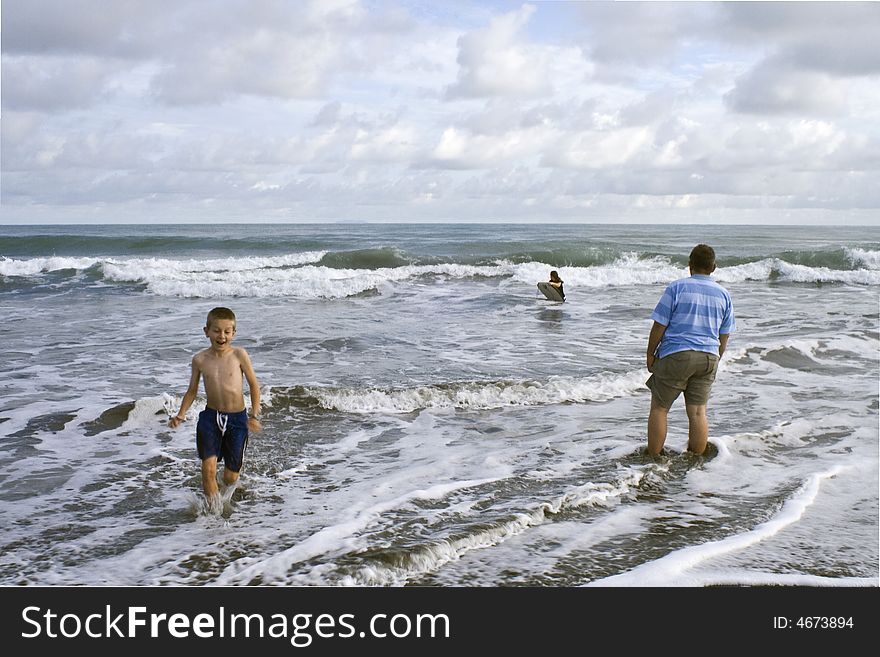 Father with children in the surf. Father with children in the surf