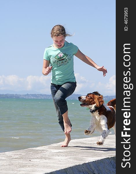 Teenage girl running with her dog at the beach. Teenage girl running with her dog at the beach