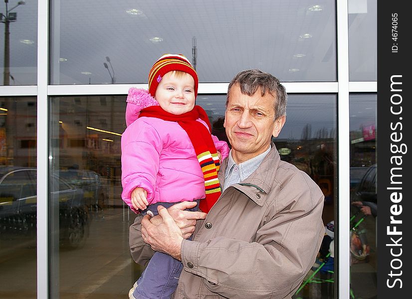 Grandfather and small grand daughter on a background of a supermarket. Grandfather and small grand daughter on a background of a supermarket