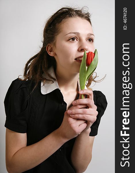 Young girl in a black dress with a tulip in her hands. Young girl in a black dress with a tulip in her hands