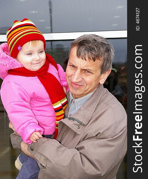 Grandfather and small grand daughter on a background of a supermarket. Grandfather and small grand daughter on a background of a supermarket