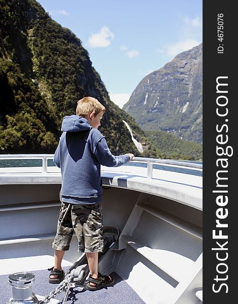 Child at front of tourist boat in Milford sound, New zealand. Child at front of tourist boat in Milford sound, New zealand