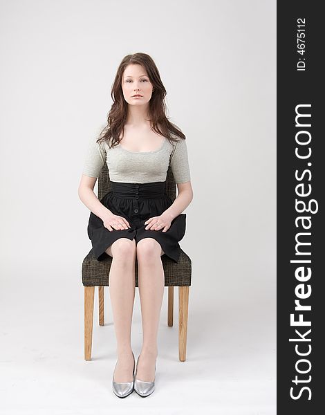 Portrait of young beautiful woman sitting on the chair