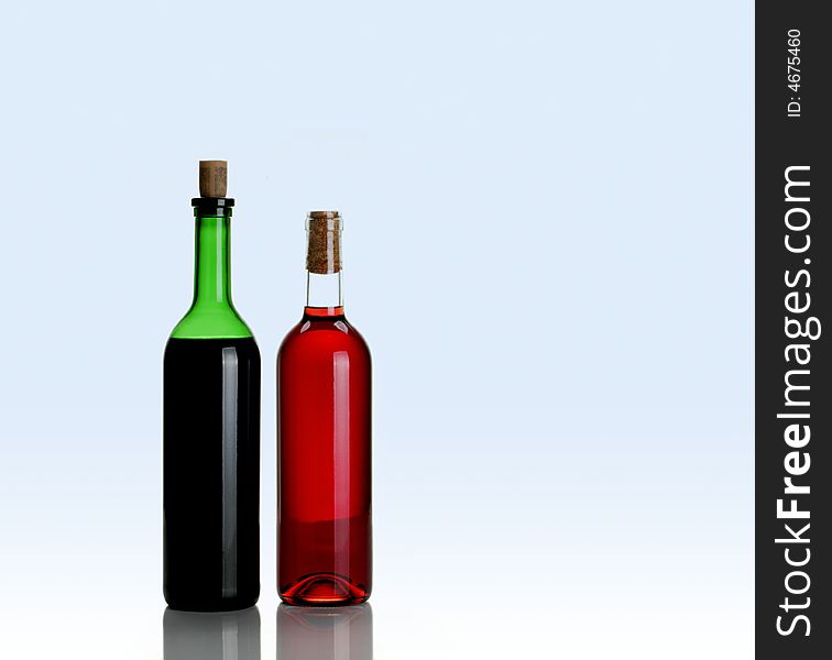 Two bottles of wine on light blue background