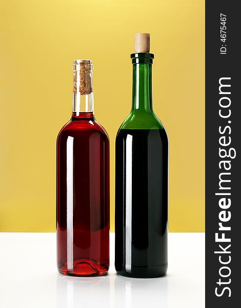Two bottles of wine on yellow background