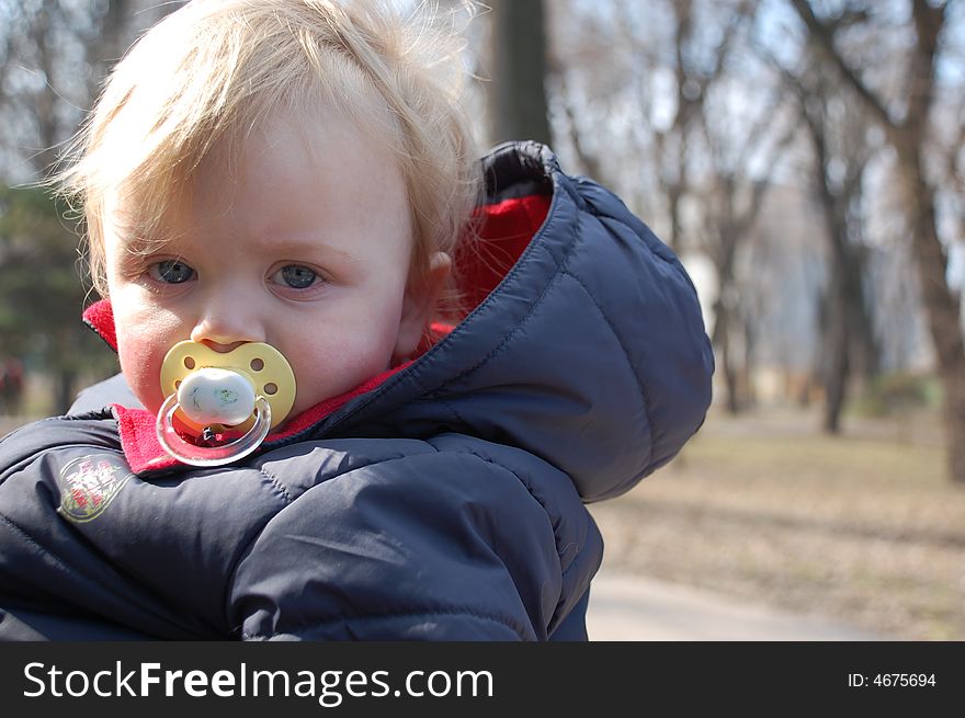 Little baby with the pacifier in the park