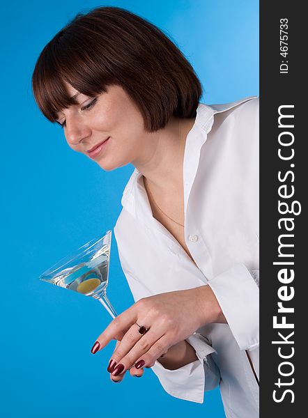 The woman in a white shirt with a glass of martini. The woman in a white shirt with a glass of martini