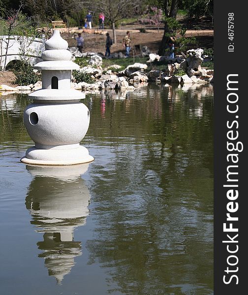 A statue set in a lake at a Chinese Garden.