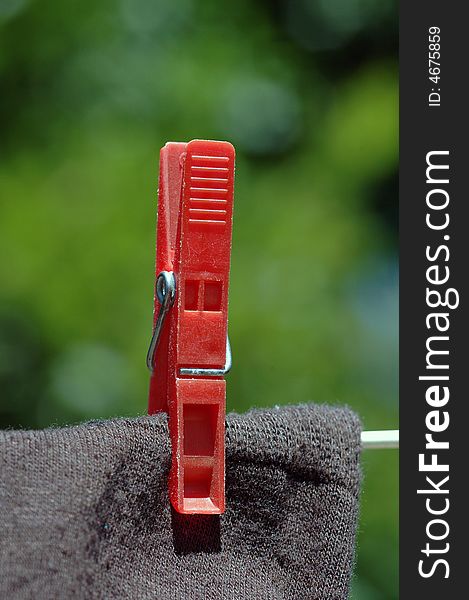 A red clothes peg on a washing line.  A macro image. A red clothes peg on a washing line.  A macro image.