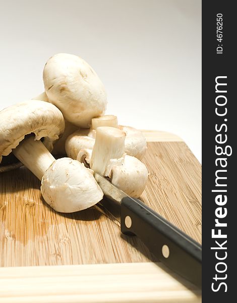 Fresh mushrooms and a knife on wood