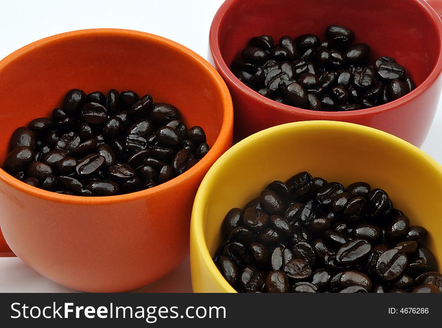 Three colorful cups full with coffee beans. Three colorful cups full with coffee beans