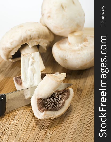 Fresh mushrooms and a knife on wood