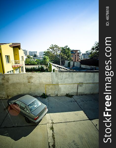 Sunny parking lot with a car parked diagonally.