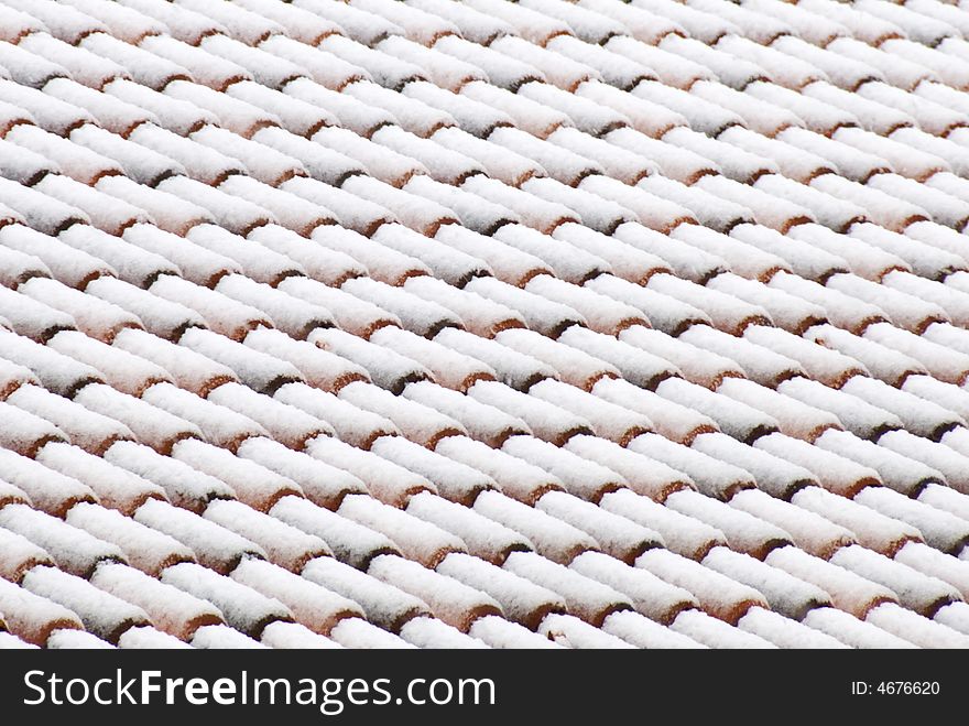 A view of a italian roof tiles under a blanket of snow. A view of a italian roof tiles under a blanket of snow