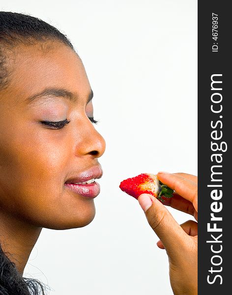 Elegant african girl going to eat a fresh red straw. Elegant african girl going to eat a fresh red straw