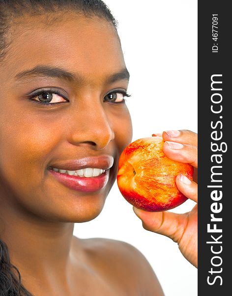 Sweet smiling african girl with a peach in her hand