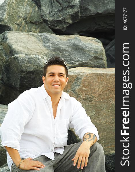 Man sitting on a rock with rocks as a background. Man sitting on a rock with rocks as a background