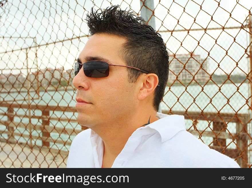 Headshot of a man standing by a fence. Headshot of a man standing by a fence