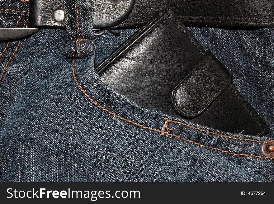 Black rich wallet in the pocket of blue jeans. Black rich wallet in the pocket of blue jeans