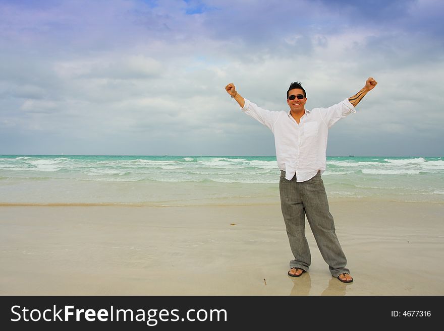 Man near the shore with his arms extended. Copy space to the left. Man near the shore with his arms extended. Copy space to the left.