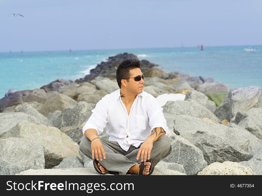 Cool young guy sitting on rocks. Cool young guy sitting on rocks