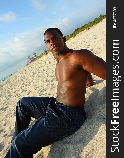 Attractive young Man sitting on the sand. Attractive young Man sitting on the sand