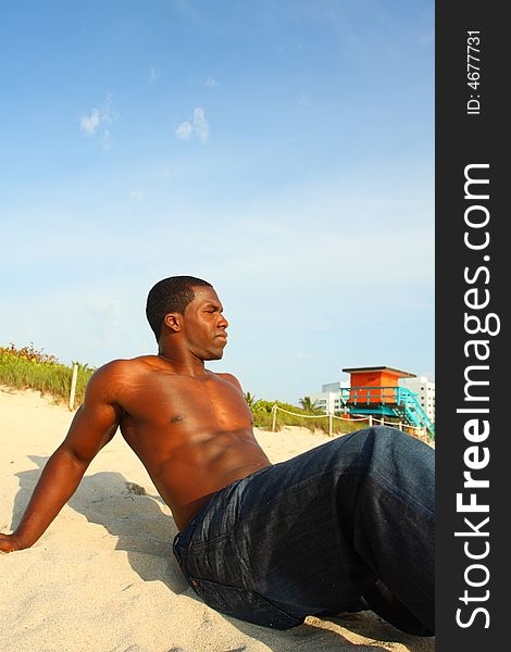 Attractive young Man sitting on the sand. Attractive young Man sitting on the sand