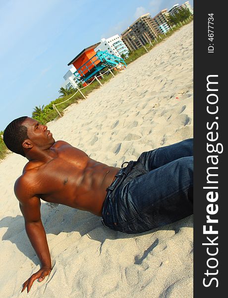 Attractive young Man sitting on the sand. Attractive young Man sitting on the sand