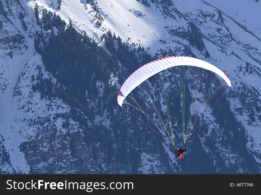Paraglider hovering in the mountains.