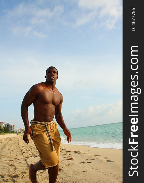 Athletic young man running on the beach