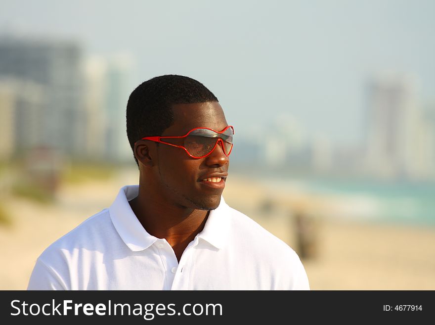 Man on the beach waring red sunglasses. Man on the beach waring red sunglasses.