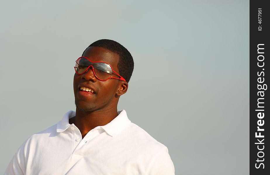 Attractive young man wearing red sunglasses.