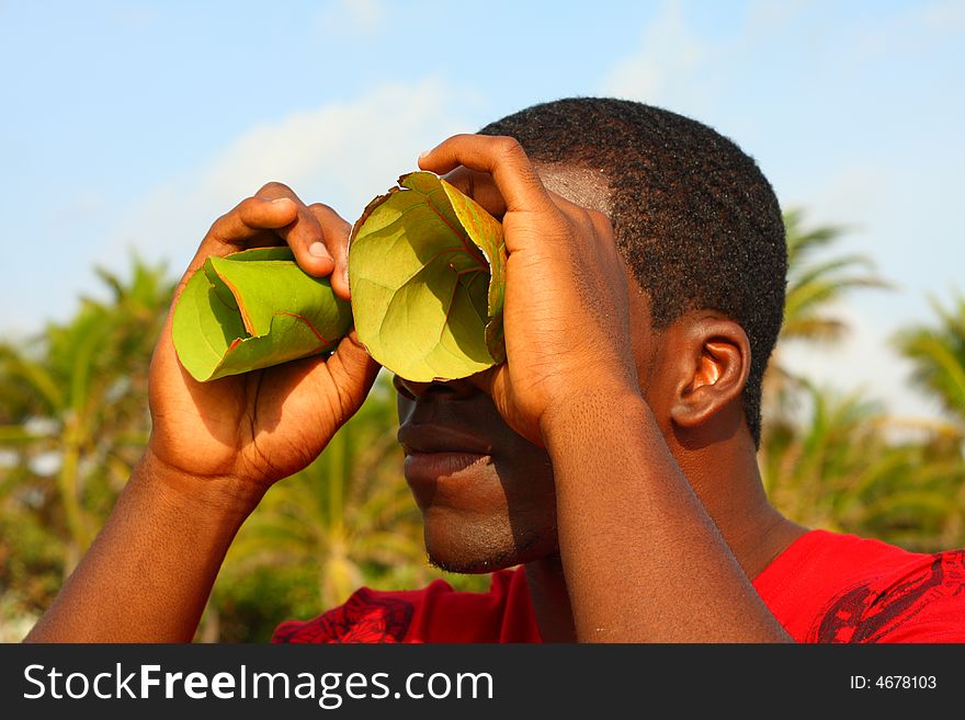 Black man looking through binoculars, leaf binoculars.