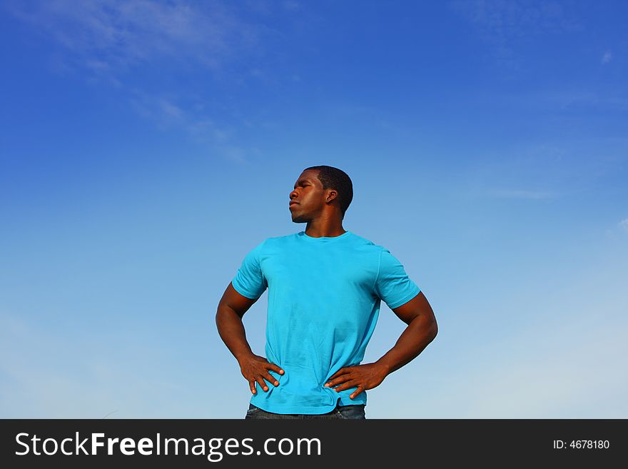 Black man standing on a blue background. Black man standing on a blue background.