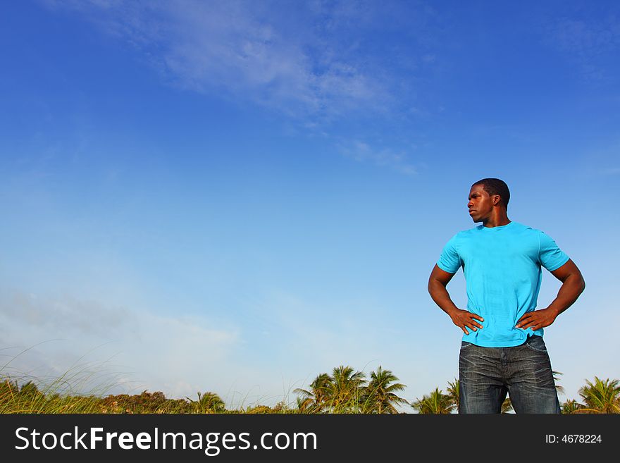 Black man standing on a blue background. Black man standing on a blue background.