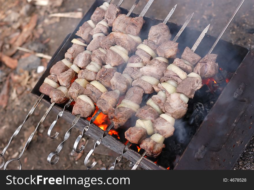 Shish kebab. roast meat on skewers on open fire. A national Caucasian dish. Shish kebab. roast meat on skewers on open fire. A national Caucasian dish