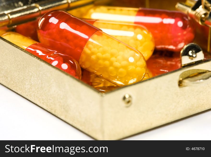 Red and yellow pills in metal container box. Red and yellow pills in metal container box