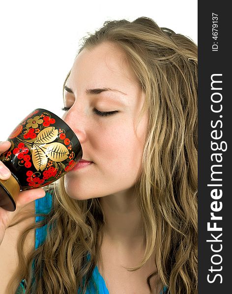 Nice young woman sipping from a colorful wooden goblet. Nice young woman sipping from a colorful wooden goblet